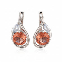 Teardrop-shaped earrings with color-changing gemstones on a white background, branded as Atta Gems.
