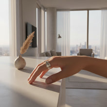 Silver ring with a bow design on a hand, branded 'GEEZENCA'.