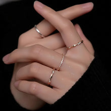 Hand wearing two silver rings with a dark background, featuring the brand 'GEEZENCA'.