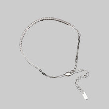 Silver anklet on a reflective surface with 'Orsa Jewels' branding.
