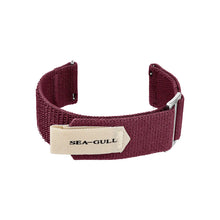 A maroon nylon watch strap with a cream-colored Sea-Gull logo tag and silver buckle.
