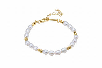 Pearl bracelet with gold accents on a brown fabric background, featuring Orsa Jewels logo.