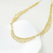 Gold necklace on a white bust with 'Geezenca' branding.