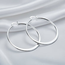 Silver hoop earrings on a light blue fabric background with 'DOTEEFL' branding.