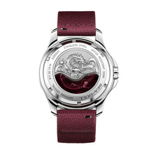 The back of a Seagull stainless steel watch featuring an engraved dragon and a burgundy nylon strap.
