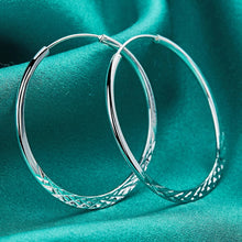 Silver hoop earrings on a teal fabric background with 'Doteffil' branding.