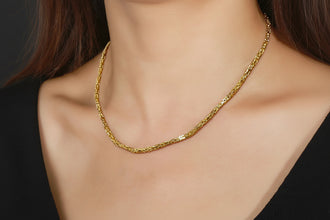 Gold necklace on a model with RINNTIN branding