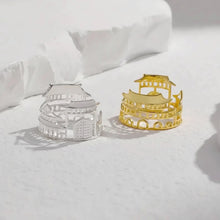 Two metallic ring molds shaped like pagodas on a white fabric background with 'GEEZENCA' branding.