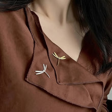 Brown blouse with embroidered dragonfly designs on a blurred background