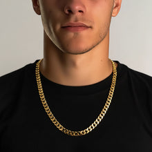 Man wearing a gold chain necklace against a neutral background
