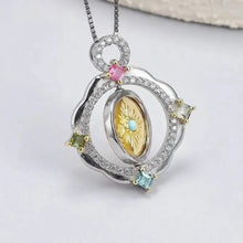 Elegant silver pendant with gemstones on a white background, featuring the brand 'Geezenca'.