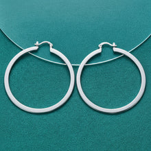 Silver hoop earrings on a teal background with 'DOKEFFIL' branding.