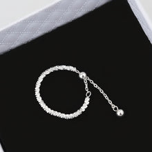 Silver bracelet on a black cushion with 'GEEZENCA' branding.