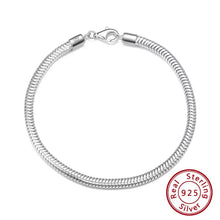 A silver snake chain bracelet with a lobster clasp, displayed on a white background with a brand logo in the top-left corner and a 'Real Sterling Silver 925' seal in the bottom-right.