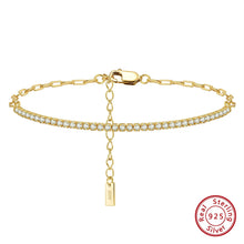 Gold bracelet with a tag and clear stones on a white background, featuring Orsa Jewels branding.
