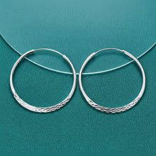 Silver hoop earrings on a teal background with 'Doteffil' branding.