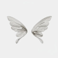 Silver wing-shaped earrings on a light gray background with 'Geezenca' branding.