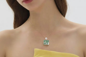 Necklace with a green pendant worn by a model, featuring the brand 'GEEZENCA'.