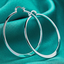 Silver hoop earrings on a teal fabric background with 'DOOTEFFI' branding.