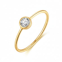 A gold-plated solitaire ring with a round bezel-set clear gemstone, shown on a white background with the Orusa Jewels logo in the top-left corner and a '925 Sterling Silver' stamp in the bottom-right.