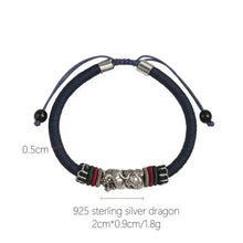 Navy blue bracelet with silver dragon charm on a white background