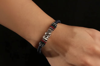 Bracelet with metal charms on a wrist, brand 'GEEZENCA' visible