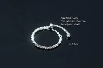 Silver anklet with adjustable extension chain on a dark background, featuring the brand 'Geezenca'.